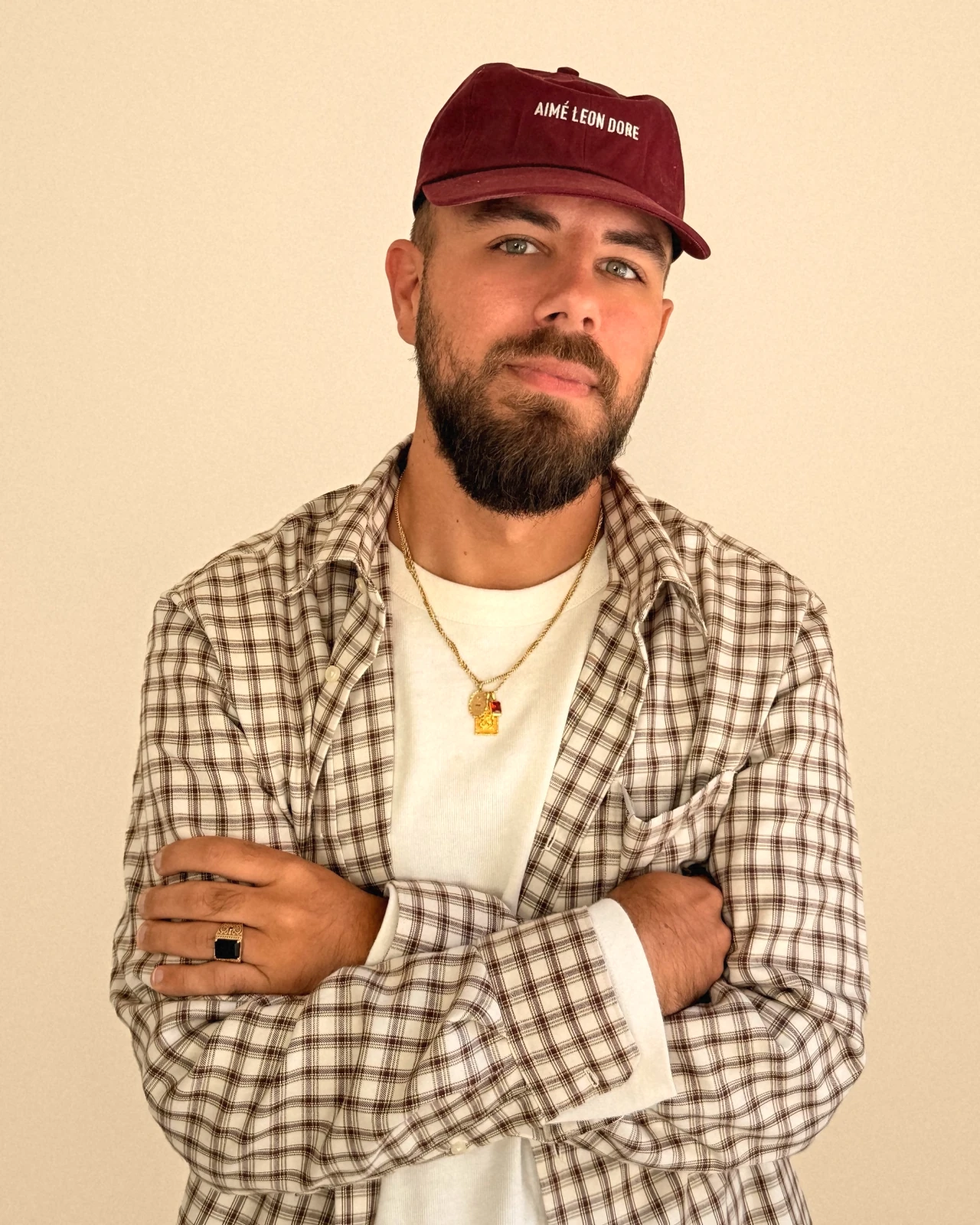 Quinn Frehner in a burgundy cap and plaid shirt, arms crossed