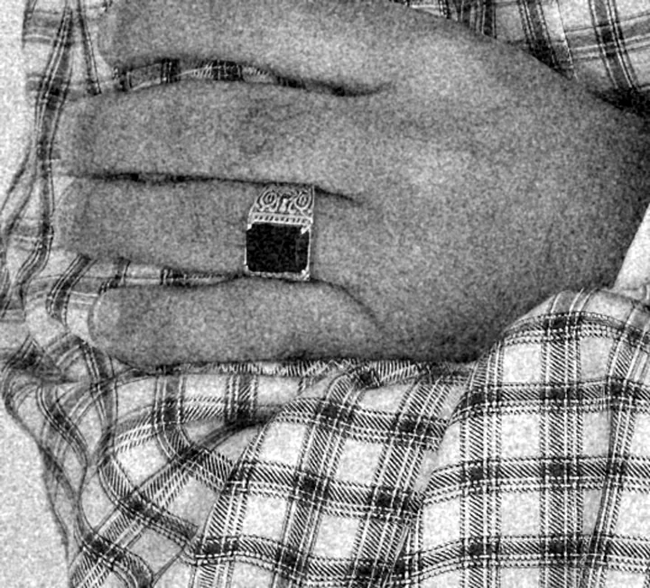 Hand with signet ring on plaid